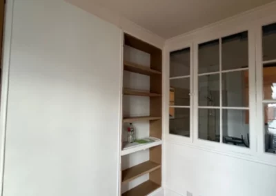 Espace avec étagères intégrées et parquet en bois.