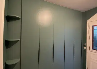 Placard vert avec étagères arrondies et carrelage décoratif.